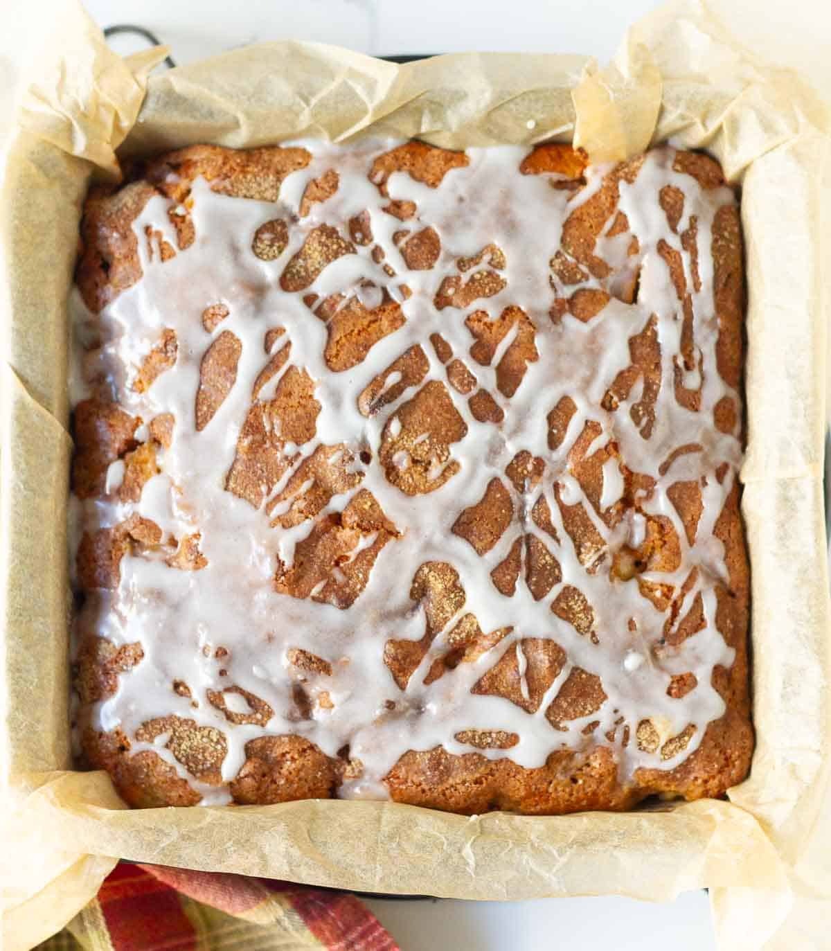 Cake with glaze on top in a cake pan.
