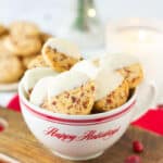 A red and white cup filled with cookies dipped in melted white chocolate.