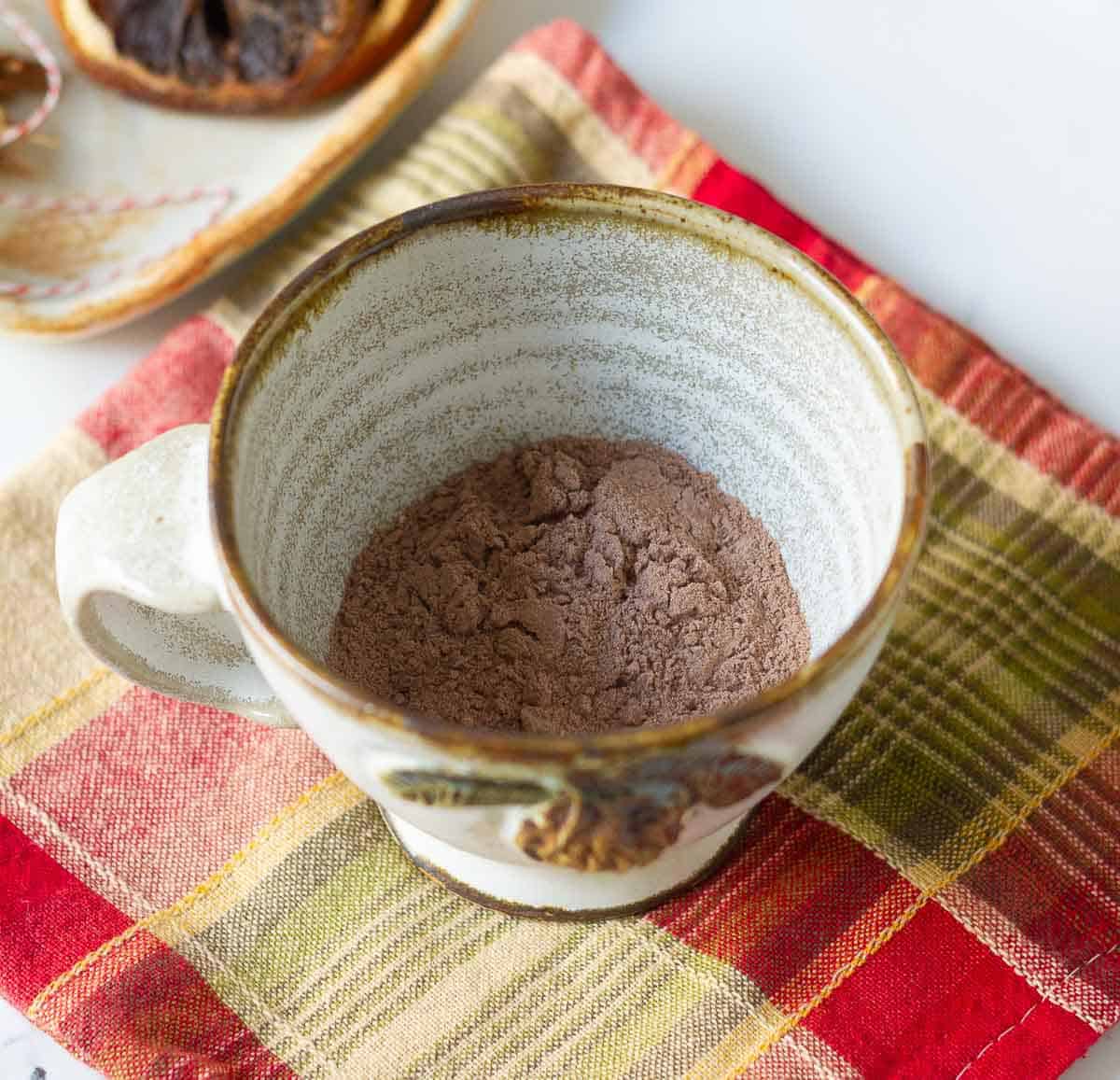 Cocoa mix in a cup on a red and green napkin.