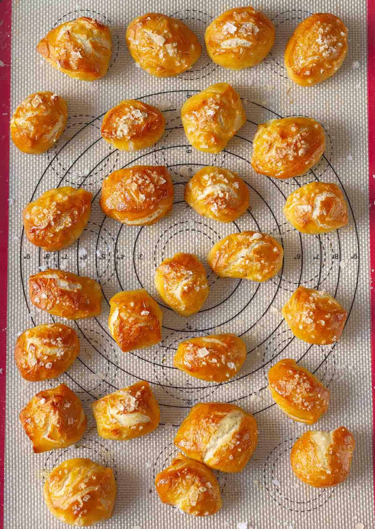 Baked pretzel bites on a silpat-lined baking tray.