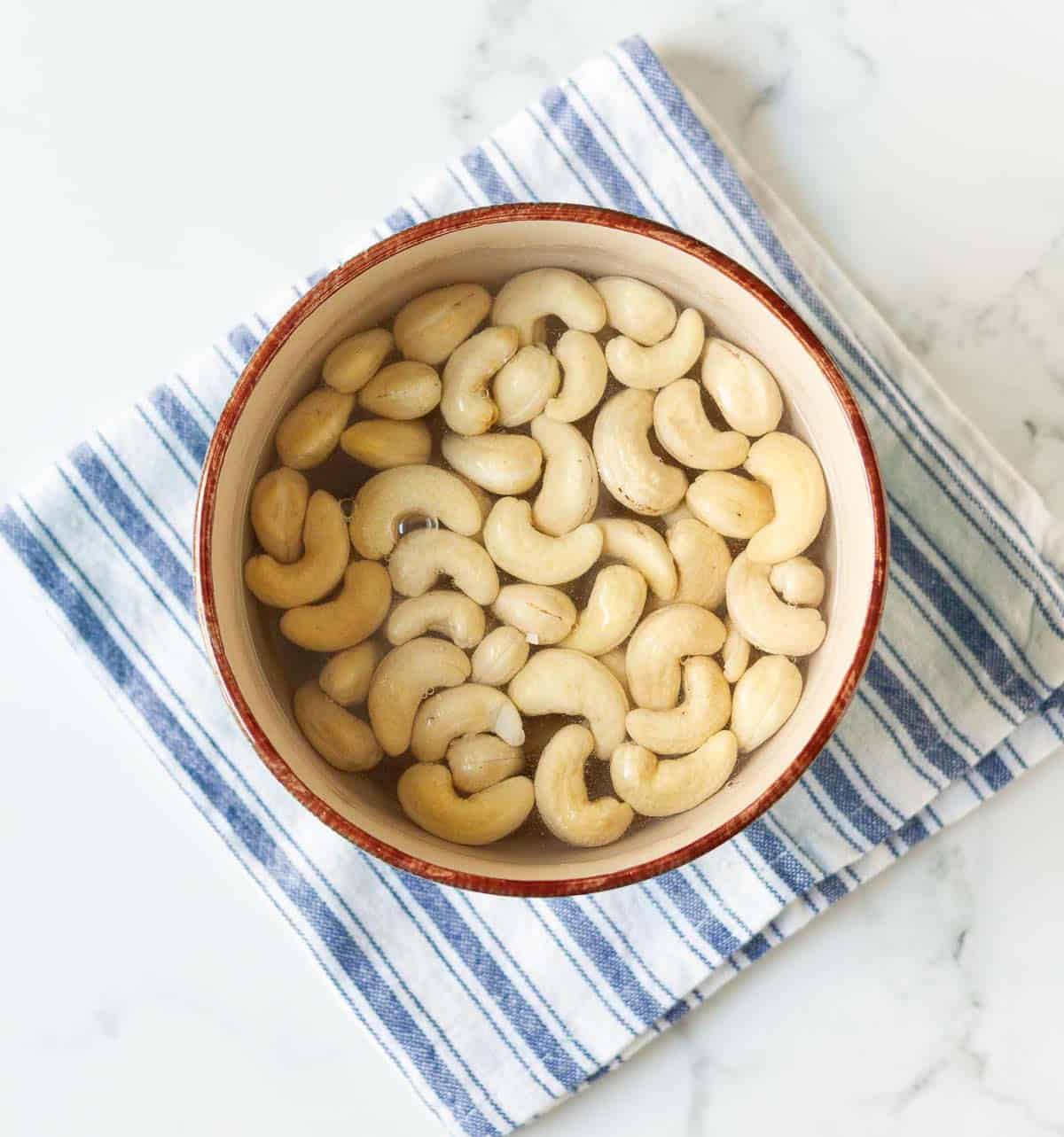 Cashews soaked in water in a bowl.