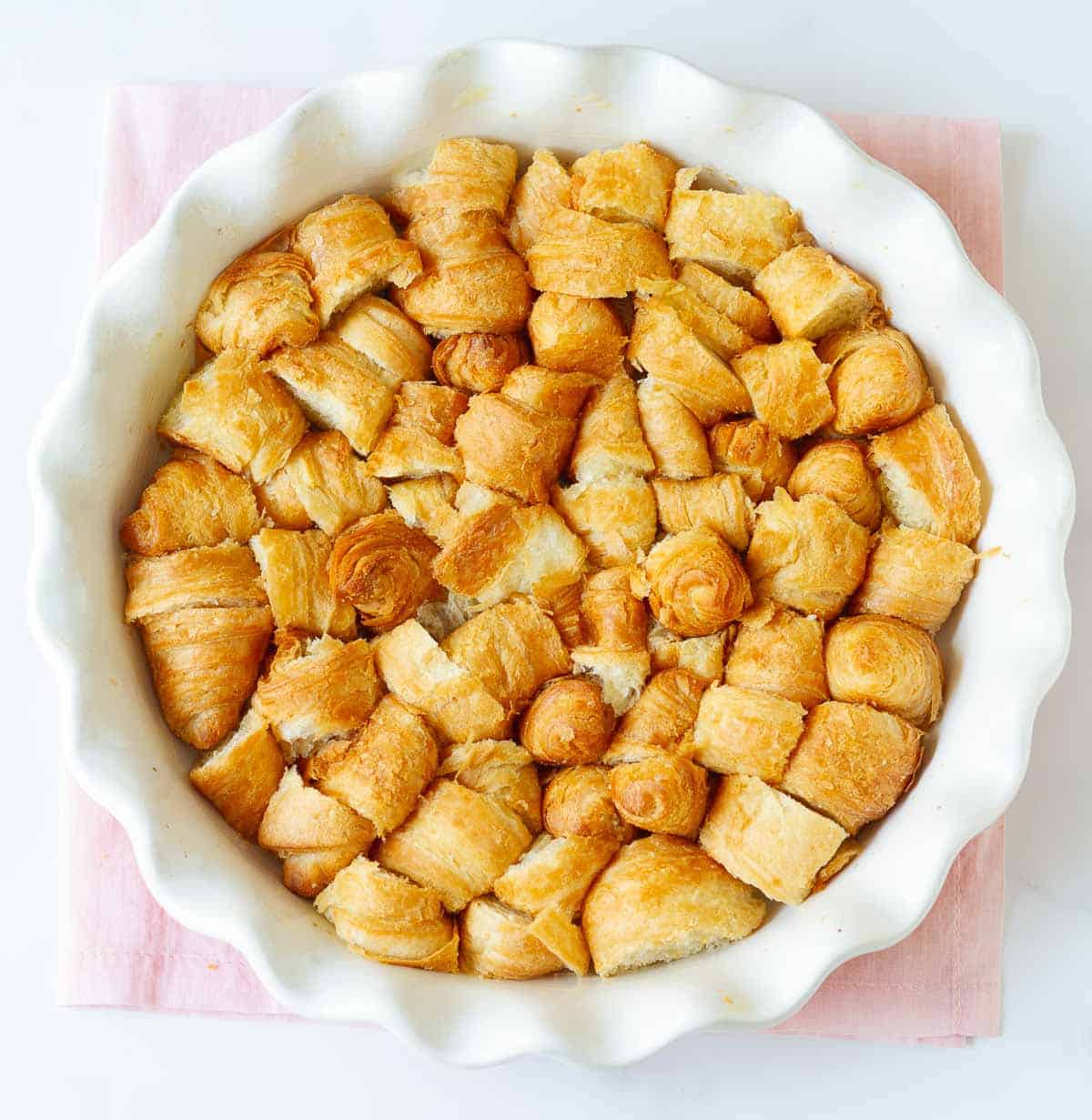 Cut up croissants in a round baking dish.