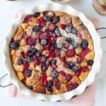 Baked croissant and berries casserole with powdered sugar on top.
