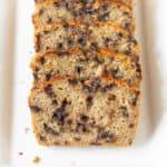 Sliced chocolate chip banana bread on a white platter.