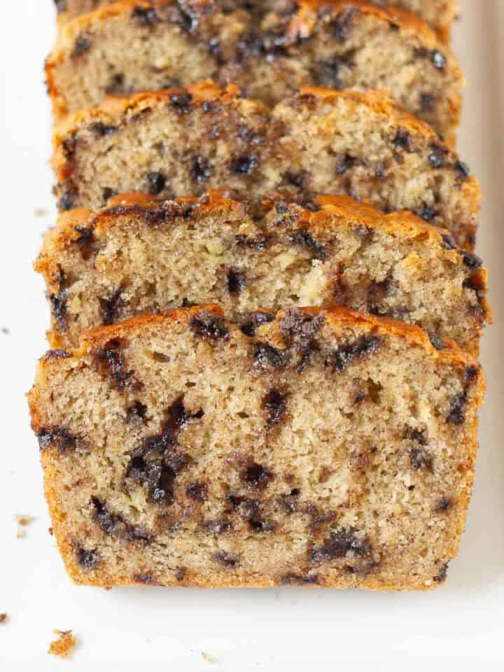 Sliced chocolate chip banana bread on a white platter.