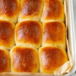 Bread rolls in a parchment-lined baking dish.