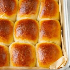 Bread rolls in a parchment-lined baking dish.