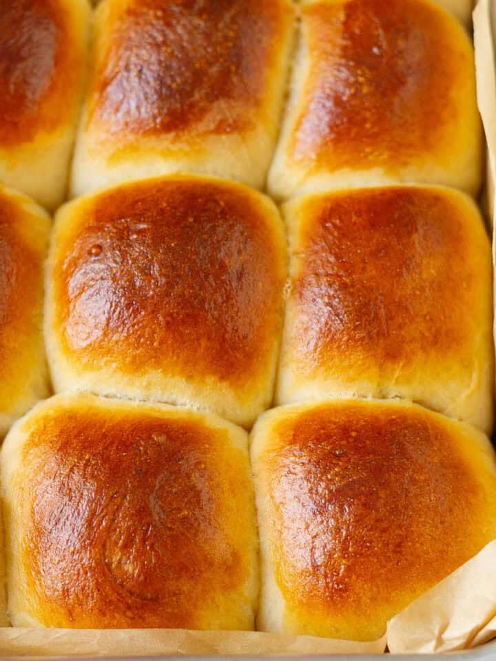 Bread rolls in a parchment-lined baking dish.
