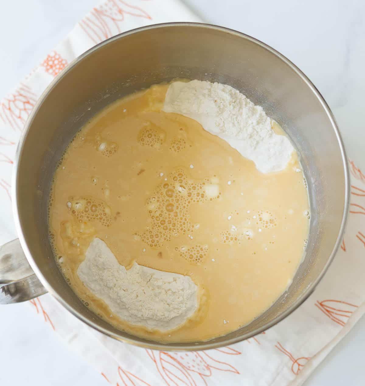 Wet and dry ingredients in a stand mixer bowl.