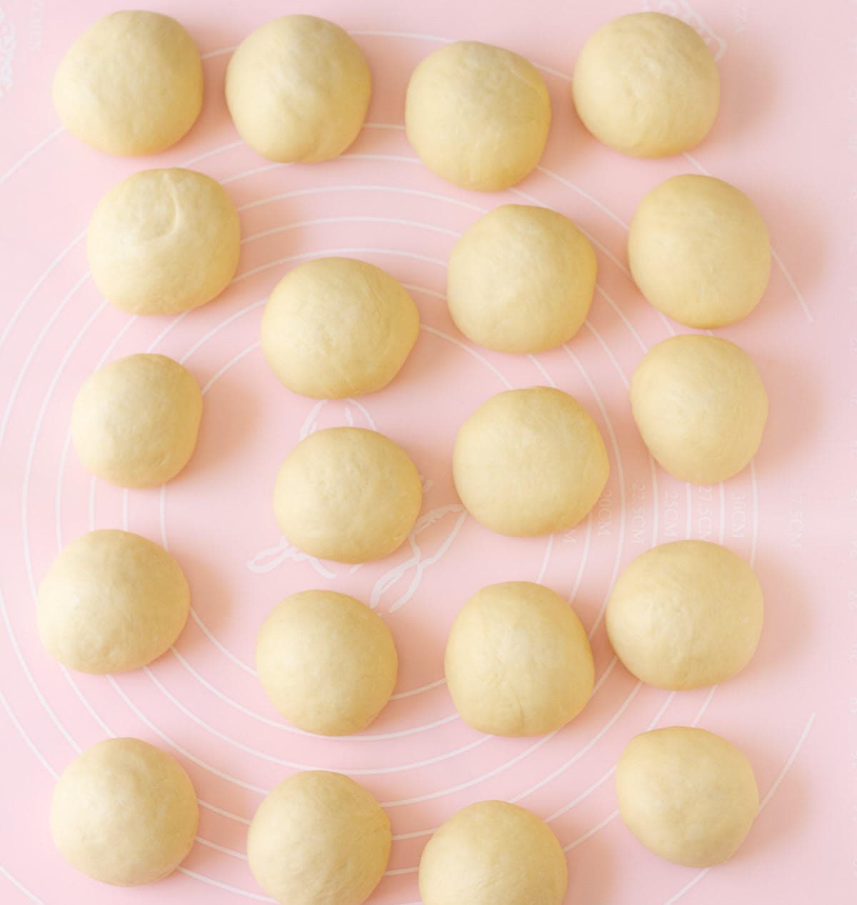 Dough balls on a pink silicone mat.