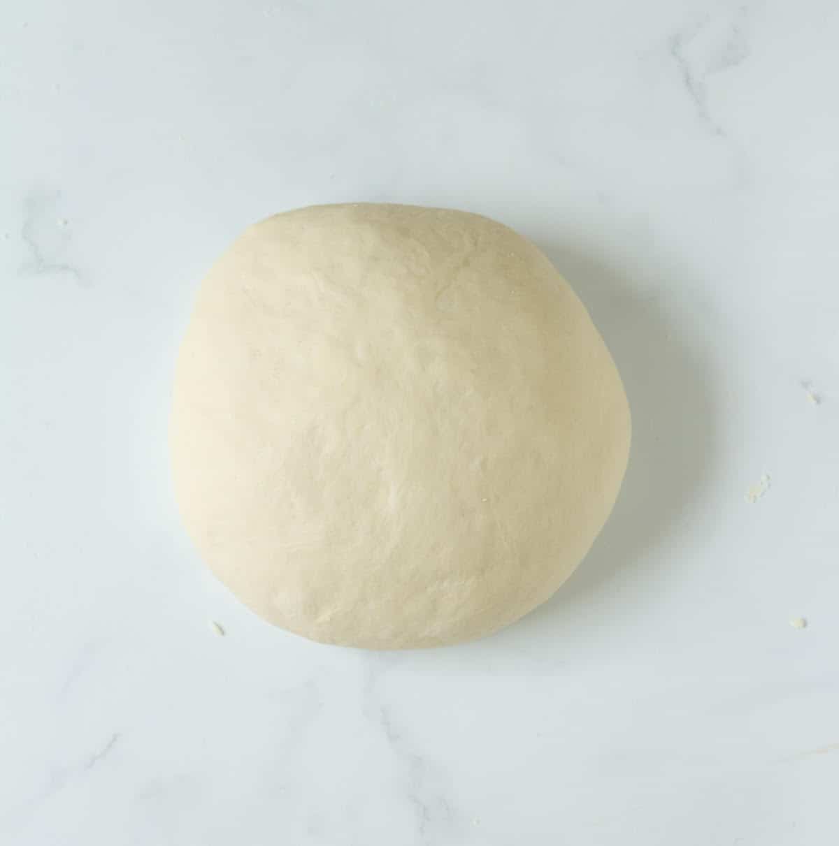 Kneaded dough ball on a surface.